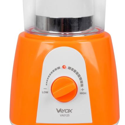 Pomarančový mixér s priehľadnou nádobou má otočný ovládač s nastavením nízkej a vysokej rýchlosti. Na ovládači svieti červená kontrolka. Na spodku je viditeľné logo Vayox a označenie VA0125.