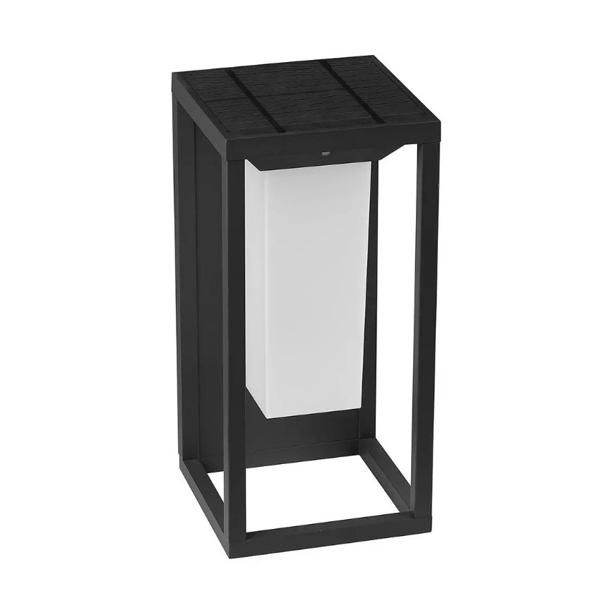 Solárny vonkajší svietiaci stĺpik, ktorý svieti, je umiestnený na exteriéri. Má čierny kovový rám a biely svetelný zdroj. Solárny panel je na vrchu.