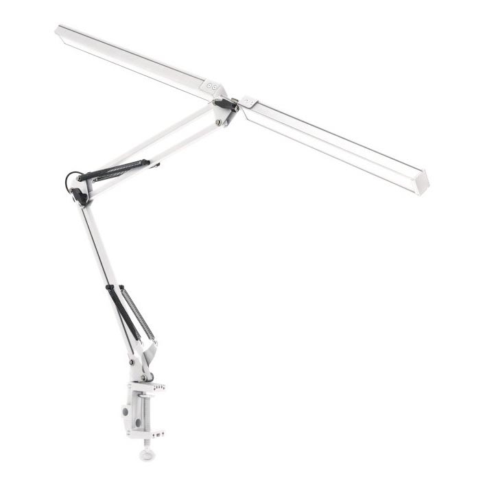 Biela stolná lampa s dlhým ramenom je pripevnená k stolu pomocou svorky. Lampa je v uhle a smeruje doprava. Na bielom pozadí.
