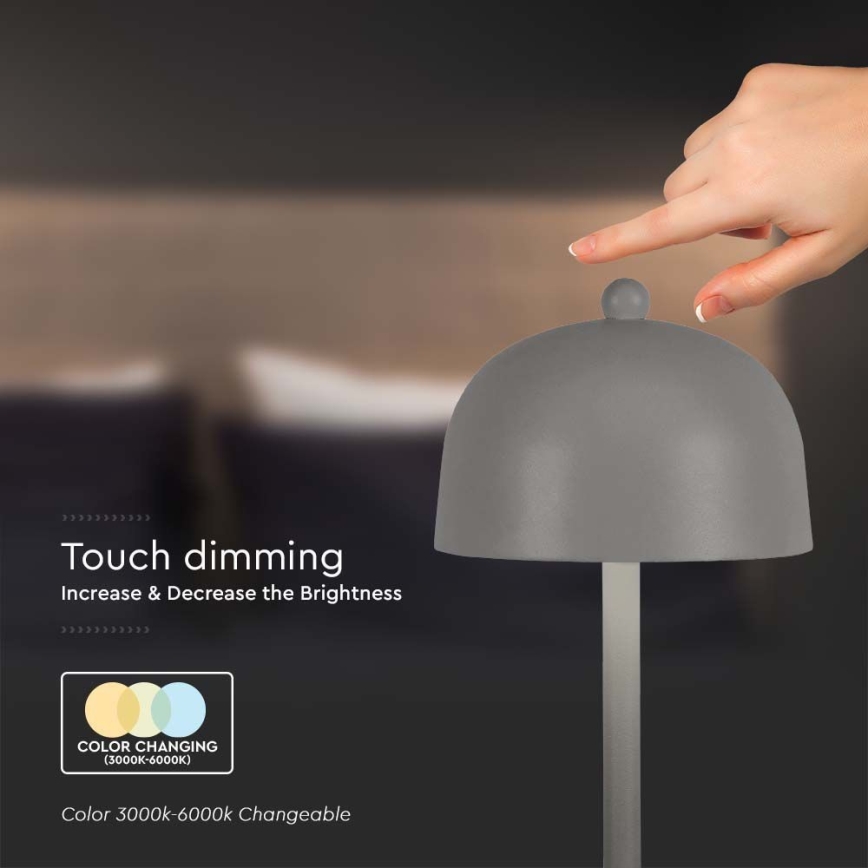 Šedá stolová lampa s kupolovitým tienidlom. Prst sa dotýka vrcholu tienidla, čím sa reguluje jas. Text uvádza: „Touch dimming. Increase & Decrease the Brightness. COLOR CHANGING (3000K-6000K). Color 3000k-6000k Changeable.“