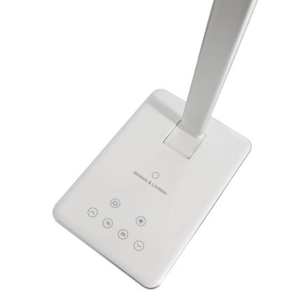 Biela stolová lampa stojí na obdĺžnikovej základni. Základňa obsahuje ovládacie tlačidlá: zapínanie/vypínanie, nastavenie jasu, časovač (1h a 2h). Na základni je text: „Wireless & Limitless“.