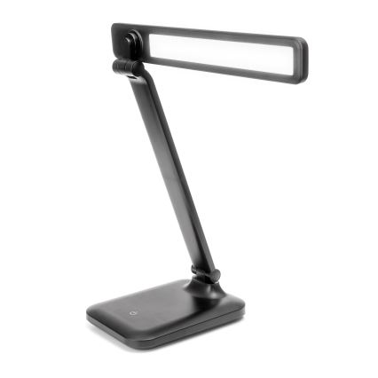 Čierna stolová lampa s dlhým, tenkým ramenom a obdĺžnikovým svetlom svieti. Lampa má malú, štvorcovú základňu. Je umiestnená na bielom pozadí.