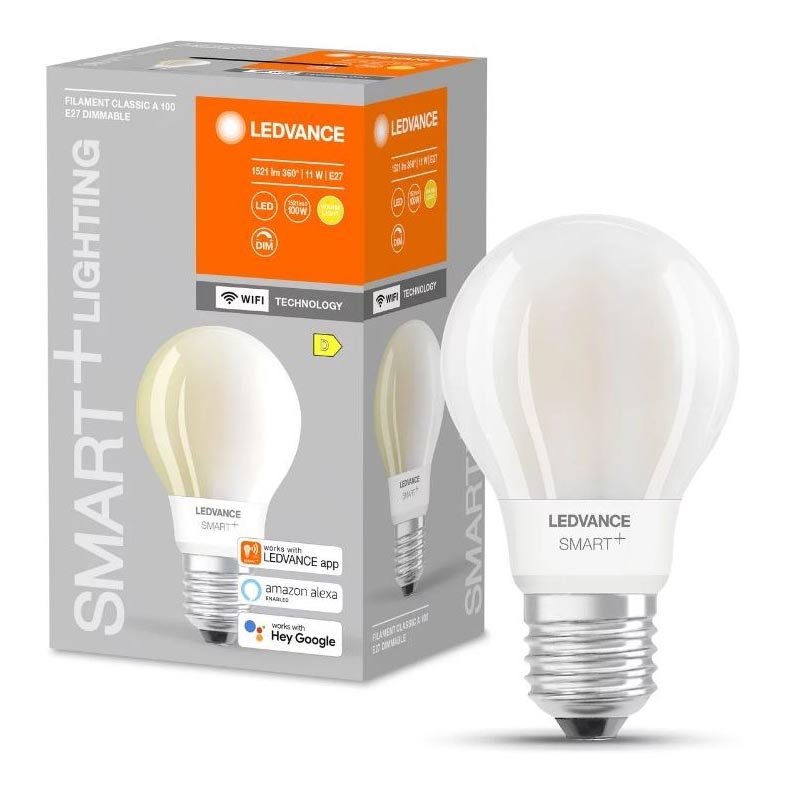 LED žiarovka s označením LEDVANCE SMART+ je zobrazená vedľa svojho balenia. Žiarovka je umiestnená na bielom pozadí. Balenie uvádza: 1521 lm 360° | 11 W | E27, LED, DIM, WiFi TECHNOLOGY, kompatibilitu s LEDVANCE app, Amazon Alexa a Hey Google.
