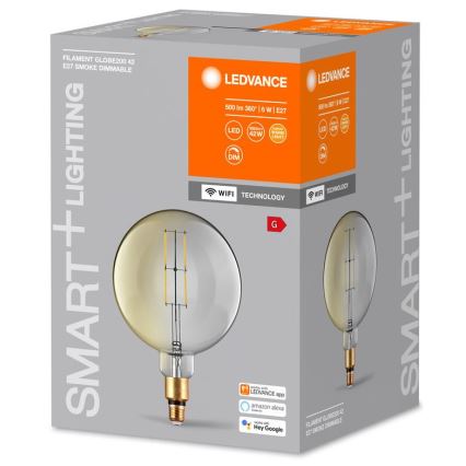 LED žiarovka – guľového tvaru s vnútorným vláknom – je zobrazená na obale s označením „SMART+LIGHTING“, „LEDVANCE“, „FILAMENT GLOBE200 42 E27 SMOKE DIMMABLE“, technickými parametrami (500 lm 360° 6 W, LED, 42W, DIM, WiFi) a kompatibilitou s aplikáciami LEDVANCE, Amazon Alexa a Hey Google.