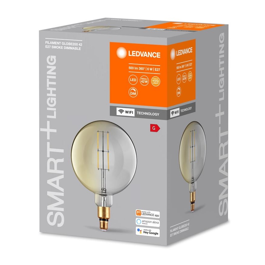 LED žiarovka – guľového tvaru s vnútorným vláknom – je zobrazená na obale s označením „SMART+LIGHTING“, „LEDVANCE“, „FILAMENT GLOBE200 42 E27 SMOKE DIMMABLE“, technickými parametrami (500 lm 360° 6 W, LED, 42W, DIM, WiFi) a kompatibilitou s aplikáciami LEDVANCE, Amazon Alexa a Hey Google.