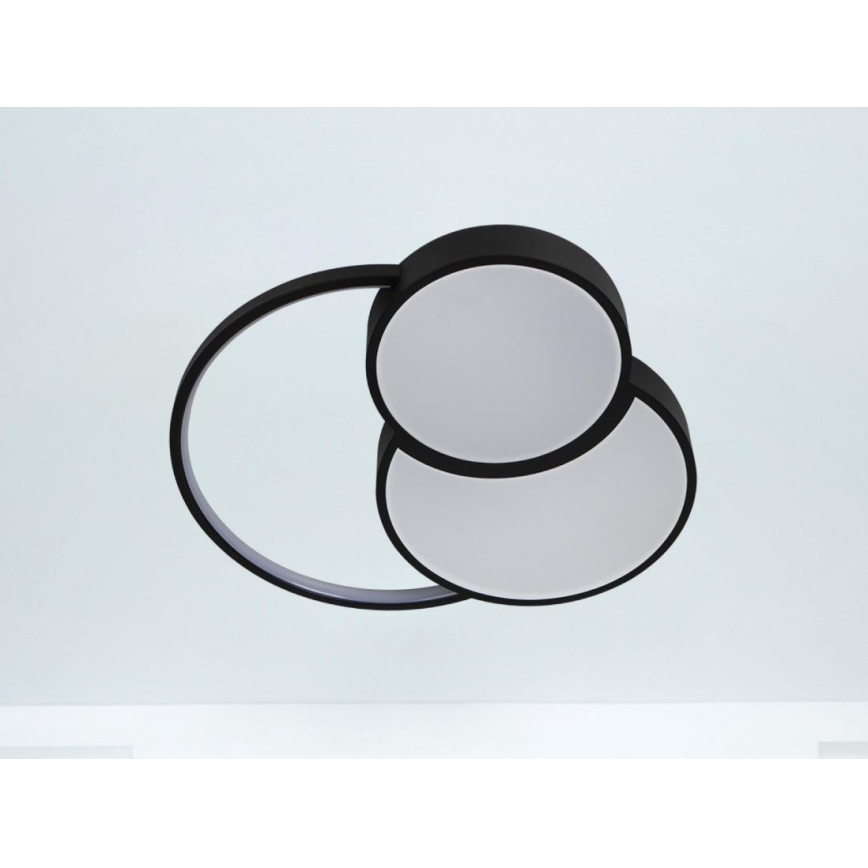 Svietidlo s dvoma kruhovými difúzormi a čiernym rámom visí pripevnené k stropu. Svetlo sa rozptyľuje z oboch difúzorov.