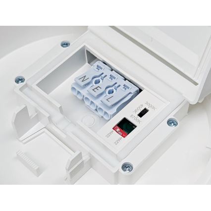 Biela plastová svorkovnica s pripojenými vodičmi je umiestnená vo vnútri otvoreného puzdra svietidla. Na puzdre je označenie: 3000k, 4000k, 5700k, 22W a 32W.