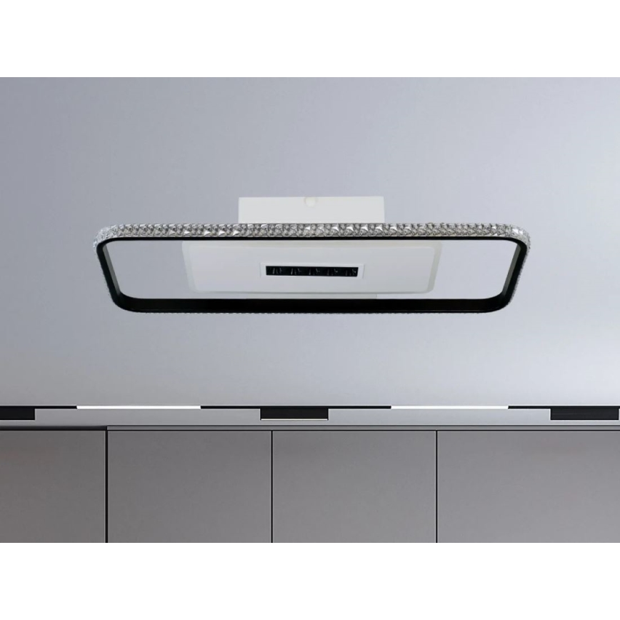 Obdĺžnikové stropné svietidlo s čiernym rámom a kryštálikmi je pripevnené k stropu nad sivou kuchynskou linkou. Svietidlo osvetľuje kuchynskú linku.