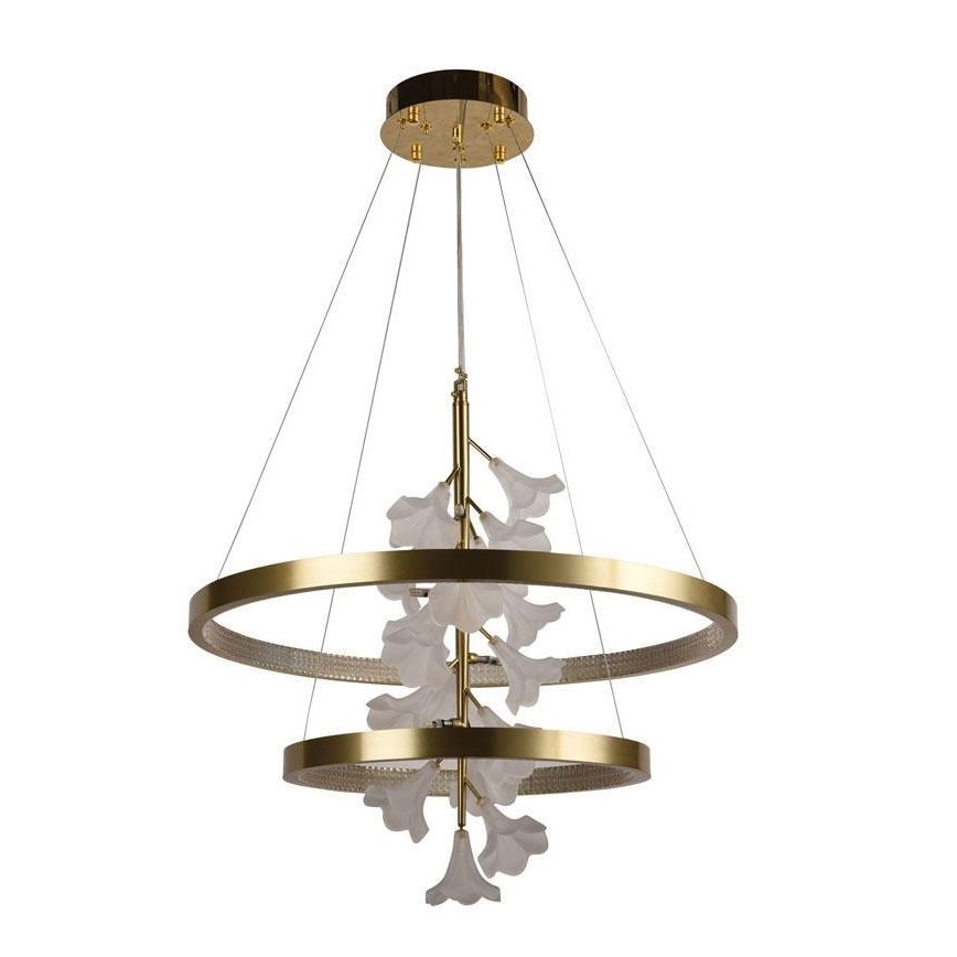 Zlatý závesný luster s dvoma kruhovými rámami a bielymi kvetmi z opálového skla visí zo stropu. Svetlá sú integrované do konštrukcie.