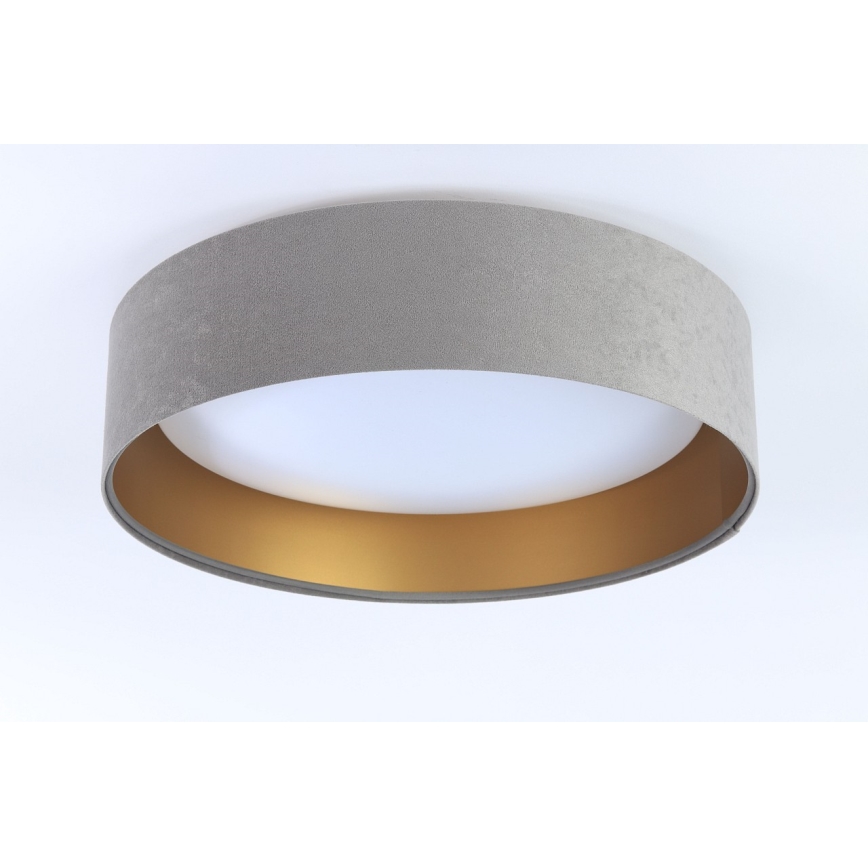 Stropné svietidlo svieti. Svietidlo je sivé, s okrajom zlata. Je pripevnené na bielom strope.