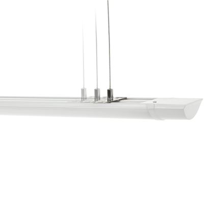 Dlhá biela LED lampa visí z troch tenkých káblov. Lampa je pripevnená k malému kovovému držiaku. Biele pozadie.