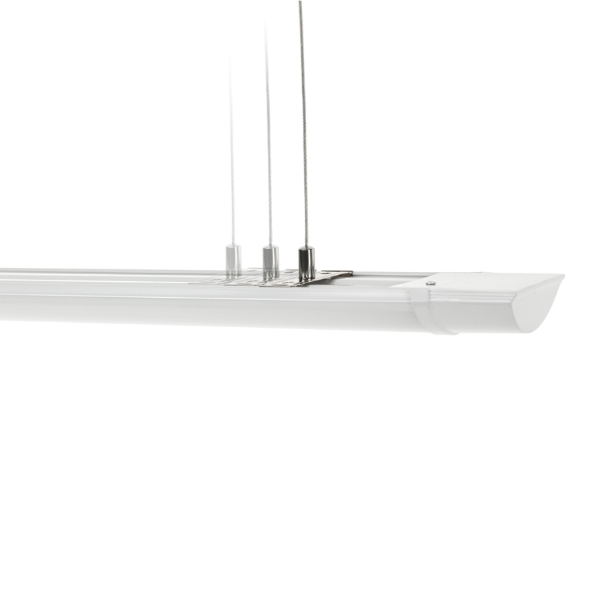 Dlhá biela LED lampa visí z troch tenkých káblov. Lampa je pripevnená k malému kovovému držiaku. Biele pozadie.
