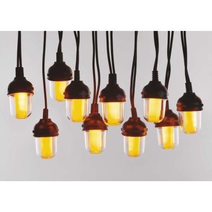 Dvanásť žiaroviek s teplým žltým svetlom visí z čiernych káblov. Žiarovky sú umiestnené na svetlom pozadí.