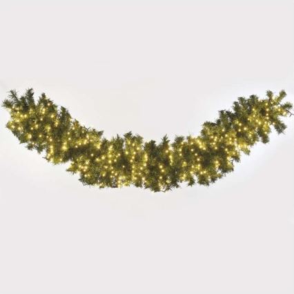Vianočná girlanda s integrovanými svetielkami je umiestnená v oblúku na bielom pozadí. Girlanda je zelená a svetielka sú žlté.