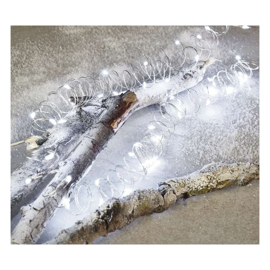 Svetelný reťaz s bielymi LED diódami je stočený na dvoch bielych konároch. Konáre ležia na snehobielom povrchu.