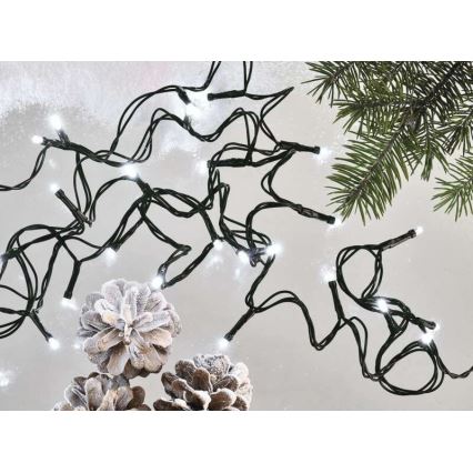 Elektrický svetelný girland s bielymi LED diódami na čiernom kábli je rozložený na ploche, pri ktorom sú umiestnené tri šišky posypané umelým snehom a vetvička ihličnatého stromu.