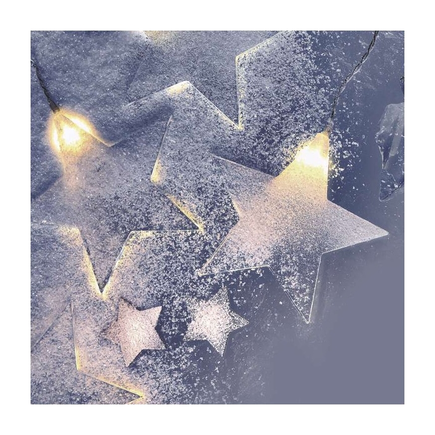 Hviezdne svetielka svietia. Sneh pokrýva hviezdy. Svetlá sú teplej bielej farby.