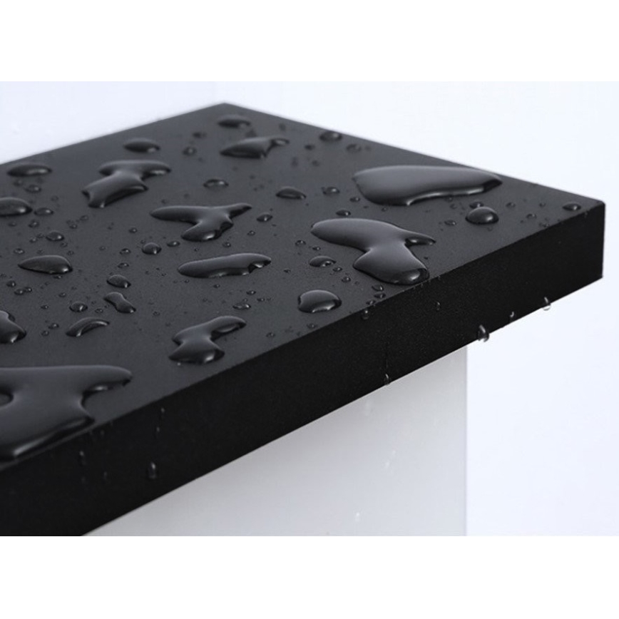 Čierny obdĺžnikový materiál odoláva vode. Na jeho povrchu sú viditeľné kvapky vody. Materiál je umiestnený na svetlom podklade.