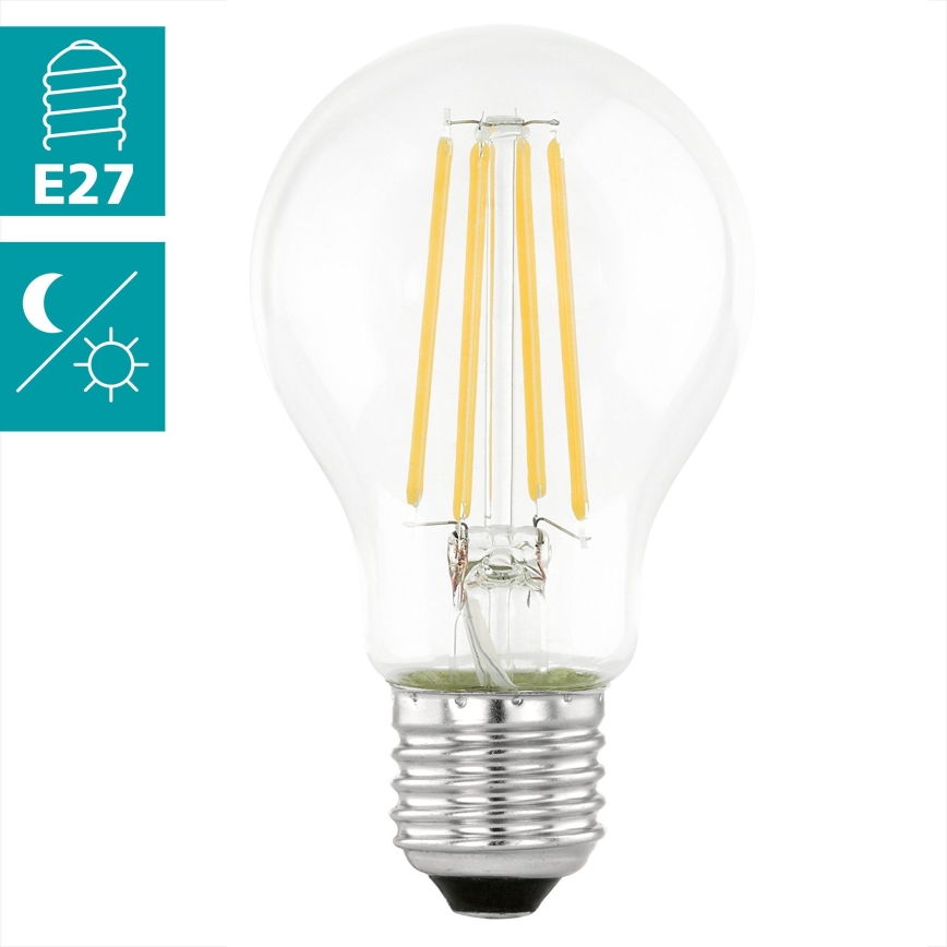LED žiarovka s päticou E27 svieti. Má sklenený obal a vnútri štyri LED segmenty. Je zobrazená na bielom pozadí s piktogramom pätice a symbolmi pre denné a nočné svetlo.