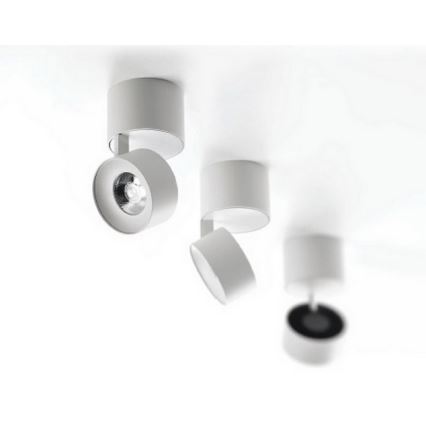 Tri stropné svietidlá s bielym valcovým telom a okrúhlym svetelným zdrojom sú namontované na strope. Svietidlá sú otočné.