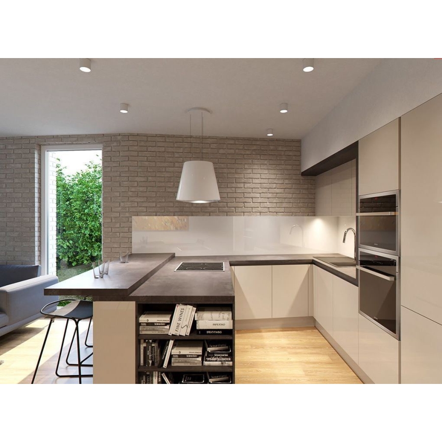Moderná kuchynská linka s ostrovčekom, zabudovanou rúrou a digestorom, sa nachádza v priestore s tehlovou stenou a výhľadom na záhradu.