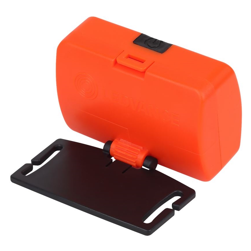 Oranžové čelové svetlo je pripevnené k čiernemu plastovému držiaku. Svetlo má vypínač.