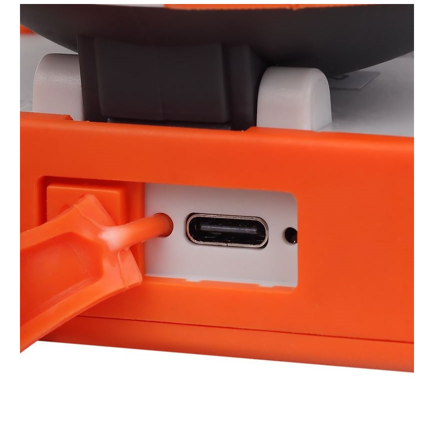 Oranžové zariadenie s USB-C portom je pripojené k oranžovému káblu. Zariadenie má sivé a biele detaily. Kábel je zasunutý do portu na bočnej strane zariadenia.