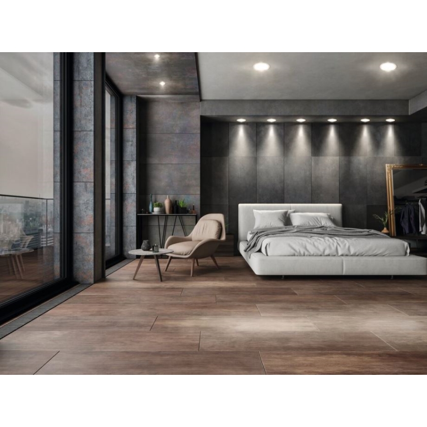 Drevená podlaha v spálni s veľkou posteľou. V miestnosti sa nachádza kreslo a konferenčný stolík. Steny sú tmavé, s veľkými oknami s výhľadom na balkón. Na strope sú zabudované svetlá.