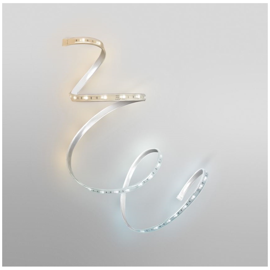 LED pásik je stočený pred svetlosivým pozadím. Pásik vyžaruje teplé a studené biele svetlo. Na jednom segmente je viditeľný text: „24V DC 12W/m 120 LED/m“.