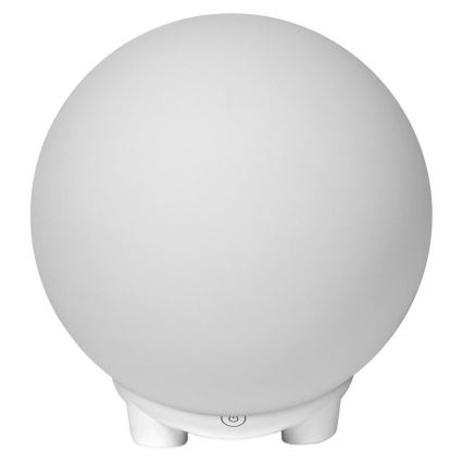 Guľová lampa svieti. Má bielu farbu a stojí na malej bielej podstavci s vypínačom. Biele pozadie.
