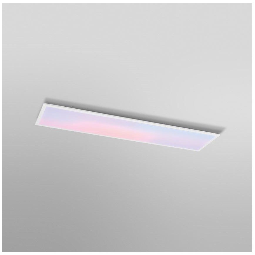 Dlhý obdĺžnikový LED panel svieti jemnými pastelovými farbami, je pripevnený k stropu svetlosivej farby.