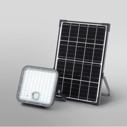 Solárny reflektor s mnohými LED diódami a zabudovaným pohybovým senzorom je umiestnený vedľa solárneho panelu na sivom pozadí. Svetlo je pripojené k panelu.