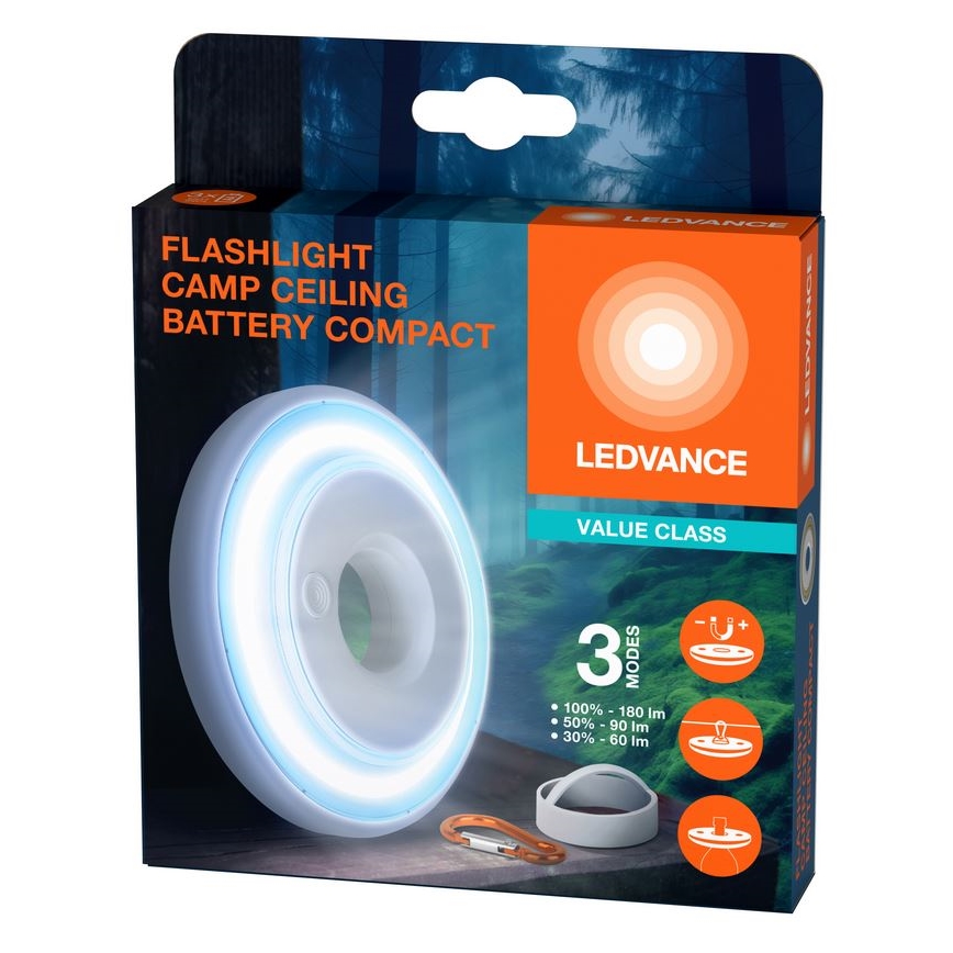 Kompaktná batériová LED lampa s okrúhlym tvarom svieti. Balenie zobrazuje lampu s karabínou a náhradnými dielmi. Na balení je text: FLASHLIGHT CAMP CEILING BATTERY COMPACT, LEDVANCE VALUE CLASS, 3 MODES, 100% - 180 lm, 50% - 90 lm, 30% - 60 lm.