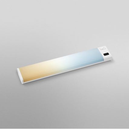 Dlhá tenká LED lampa s prechodom farieb od žltej po modrú leží na svetlošedej ploche. Na jednom konci je malý ovládací panel.