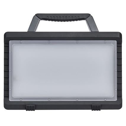 Prenositelná pracovná lampa s rúčkou na prenášanie, svieti, obdĺžniková, tmavosivá plastová konštrukcia.
