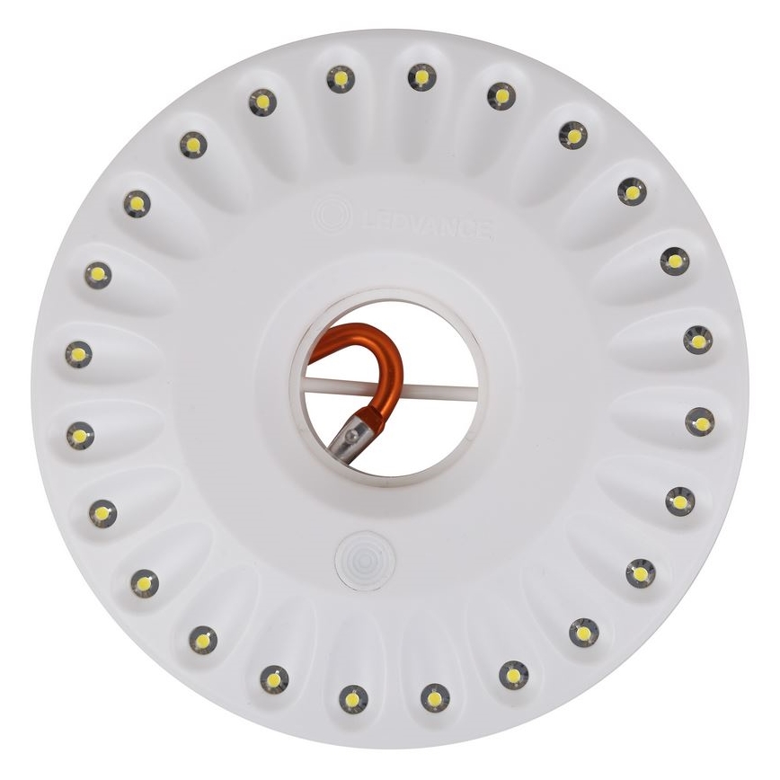 Biela okrúhla LED lampa svieti. Je pripevnená oranžovým háčikom. Lampa má okolo seba 20 LED diód.