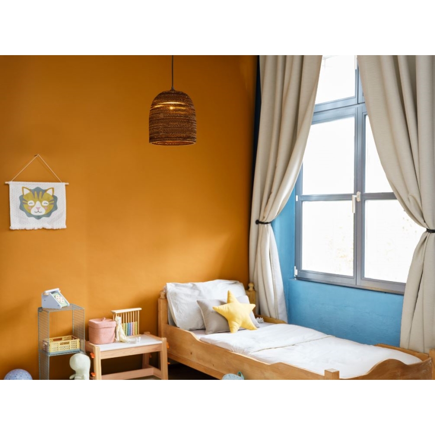 Svietidlo visí v detskej izbe. Je vyrobené z hnedého materiálu, tvarom pripomína zvon. Izba má oranžové steny, drevenú posteľ a svetlé závesy pri okne.