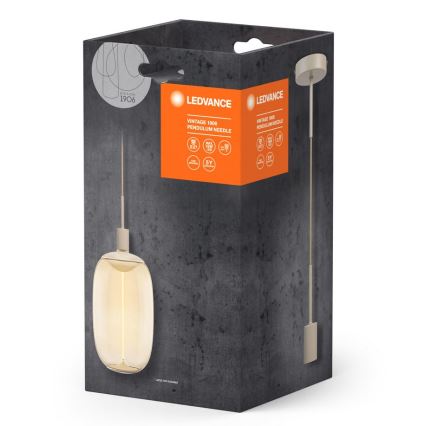 Závesné svietidlo s oválnym skleneným tienidlom je zobrazené v balení. Balenie má oranžové označenie s textom: LEDVANCE, Vintage 1906 Pendulum Needle. Na balení sú uvedené technické parametre.