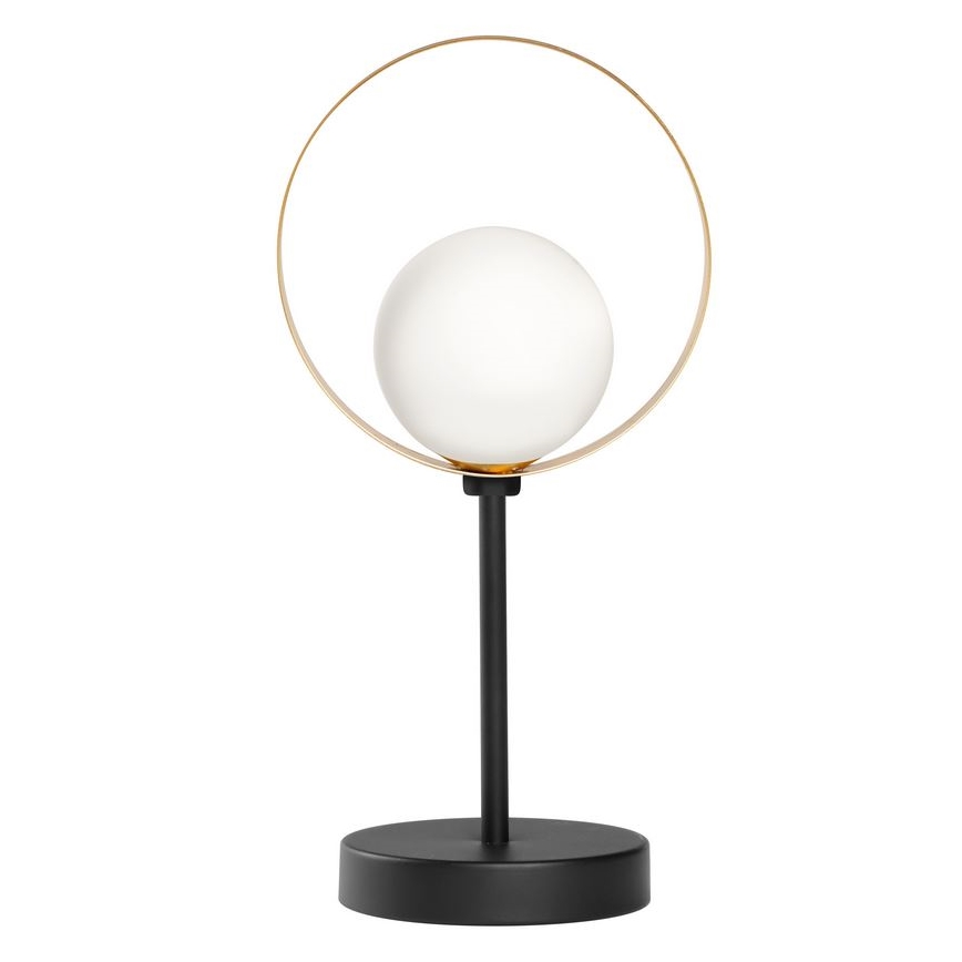 Stolová lampa s bielou guľovou tienidlom je umiestnená v zlatom kruhovom ráme na čiernej kovovej podstave. Lampa stojí na čiernej základni.