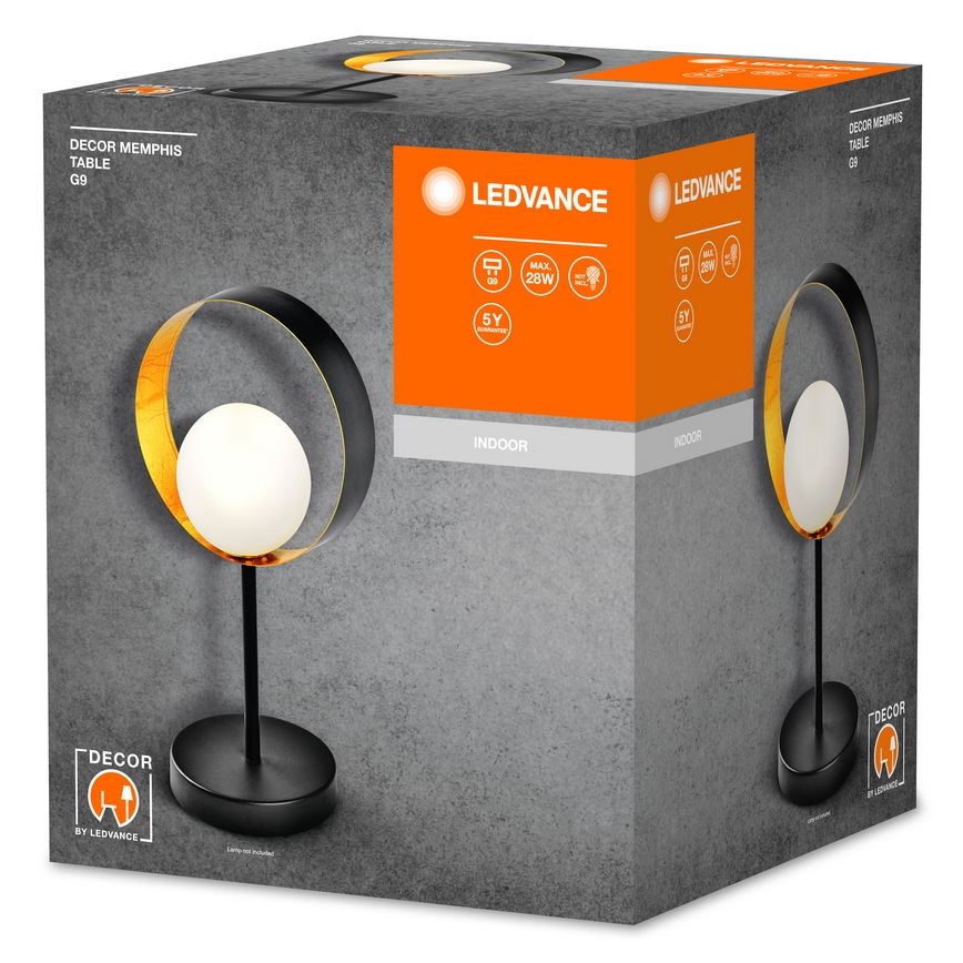 Stolová lampa s čiernym kovový rámom a zlatou povrchovou úpravou, má bielu guľovú tienidlo. Nachádza sa v kartónovej krabici s nápismi „LEDVANCE“, „DECOR MEMPHIS TABLE G9“, „MAX 28W“, „INDOOR“ a „5Y“.