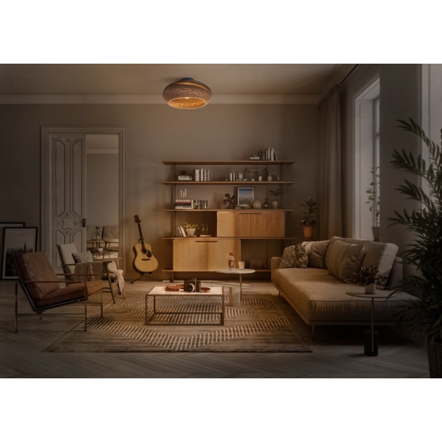 Svietidlo svieti v obývacej izbe. Je umiestnené na strope nad sedačkou, konferenčným stolíkom a gitarou. V miestnosti je drevená knižnica a kožený kreslo.