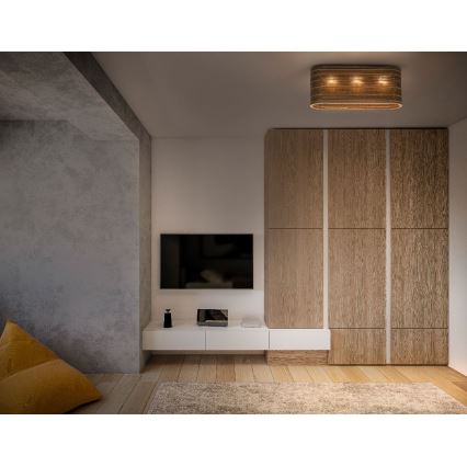 Obdĺžnikové stropné svietidlo s tromi svetlami svieti v obývacej izbe. Svietidlo je z prírodného materiálu. Izba obsahuje televízor, nábytok z dreva a svetlohnedú podlahu.