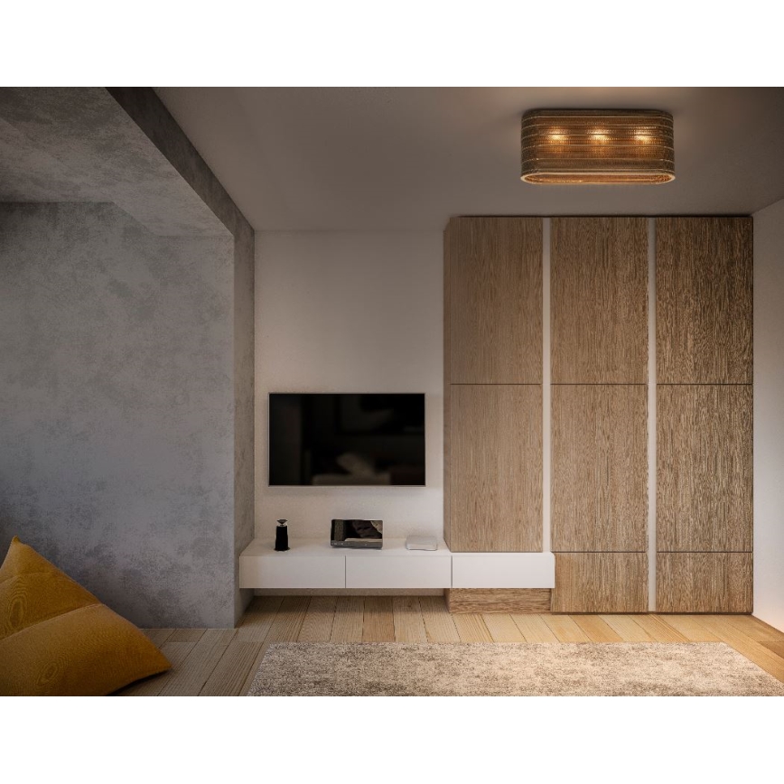 Obdĺžnikové stropné svietidlo s tromi svetlami svieti v obývacej izbe. Svietidlo je z prírodného materiálu. Izba obsahuje televízor, nábytok z dreva a svetlohnedú podlahu.