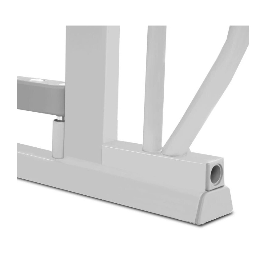 Biela kovová konštrukcia, pravdepodobne časť nábytku alebo športového náradia, spočíva na širokej základni. Konštrukcia obsahuje zvislé a šikmé rúry, spojené v pevnej základni s otvorom.
