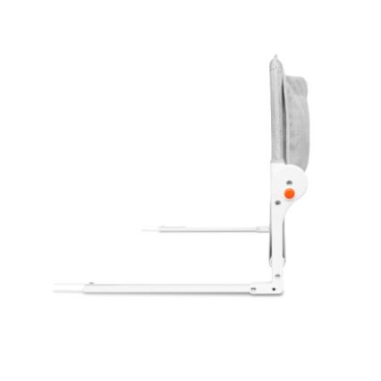 Bočná strana detskej postieľky s opierkou hlavy z sivej látky je pripevnená k bielym nohám. Opierka má oranžové tlačidlo. Postieľka je na bielom pozadí.