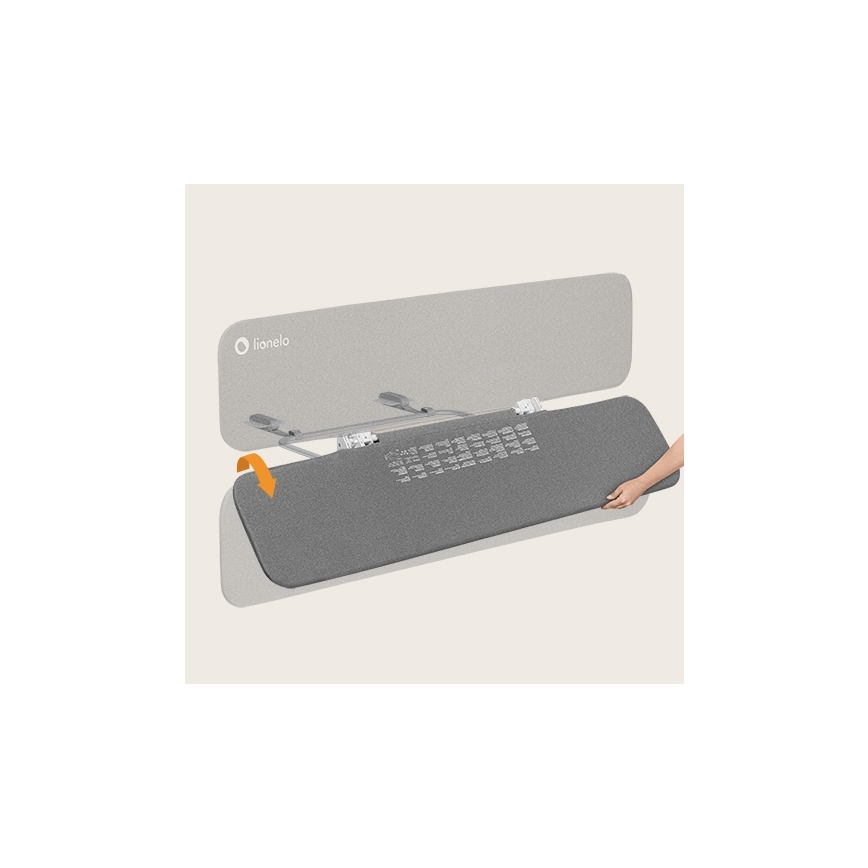 Šedá podložka sa pripája k kovovému rámu. Ruka pripevňuje podložku k rámu. Značka Lionelo je na hornej časti.