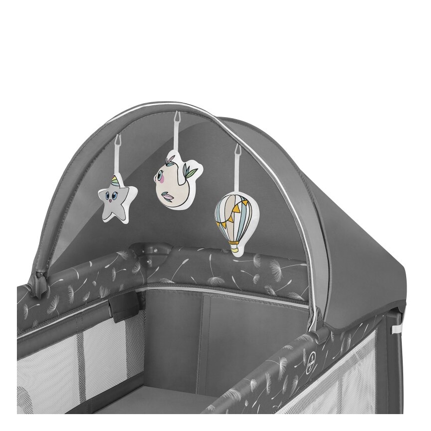 Detská postieľka s ochrannou strieškou má zavesené plyšové hračky v tvare hviezdy, vtáčika a balónu. Postieľka je sivá s motívom púpavy.