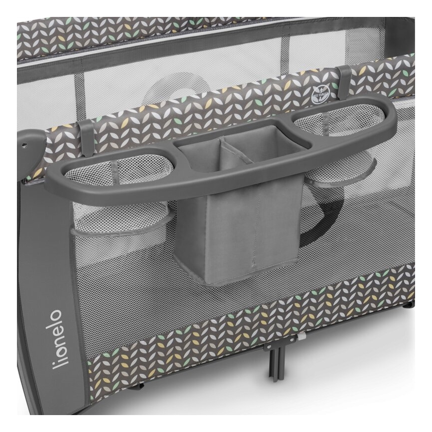 Cestovná postieľka Lionelo obsahuje odkladací priestor s viacerými priehradkami a sieťovanými vreckami. Je sivá s dekoratívnym vzorom listov v pastelových farbách. Postieľka je rozložená.