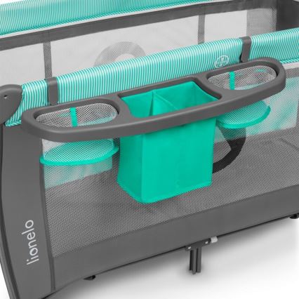 Cestovná postieľka Lionelo má pripevnenú odkladaciu plochu s dvoma sieťovanými a jedným textilným vreckom, v sivomodrej a tyrkysovej farbe.