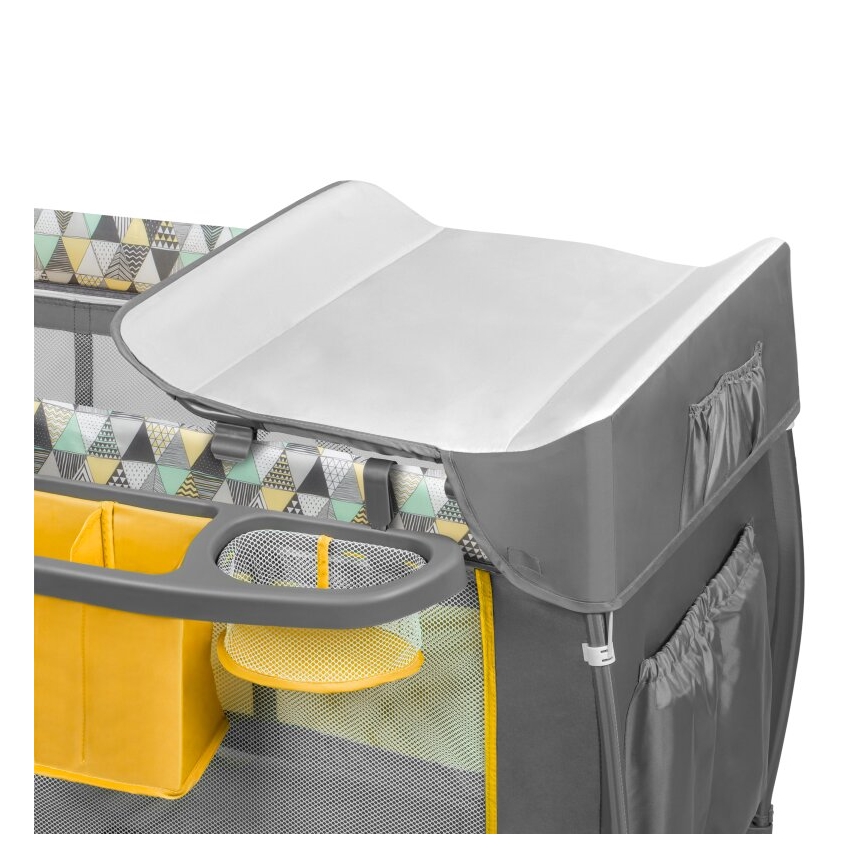 Prebaľovací pult je umiestnený na skladaciej detskej postieľke. Postieľka má šedú farbu s geometrickým vzorom a žltými doplnkami. Súčasťou je odkladací priestor s priehradkami.
